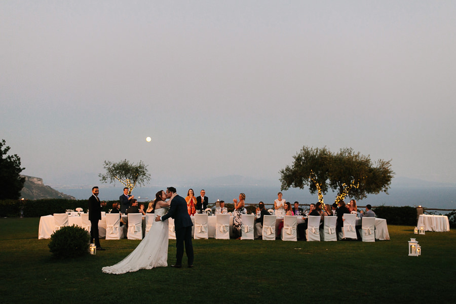 bride and groom kiss before wedding dinner