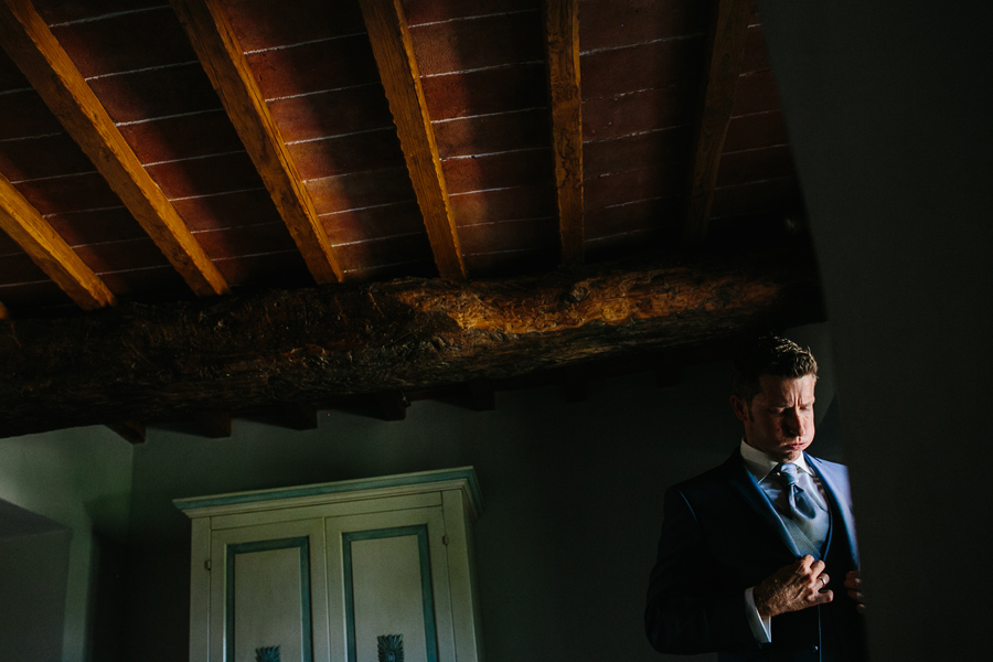 Groom dressing and breathing before his wedding in Tuscany