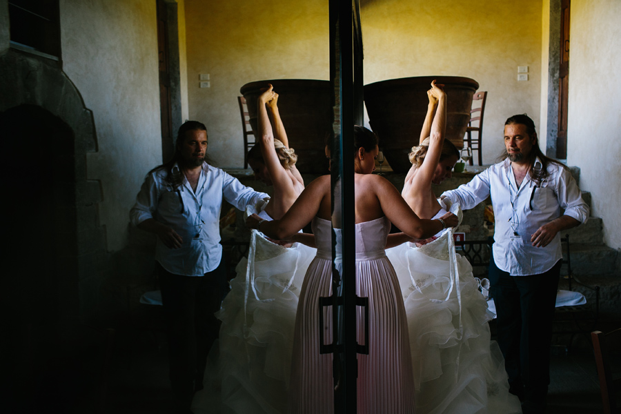 Bride putting on her dress at castello del trebbio wedding