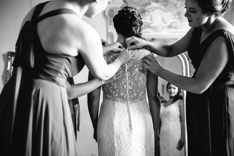 bride putting on her dress at castello di meleto wedding tuscany