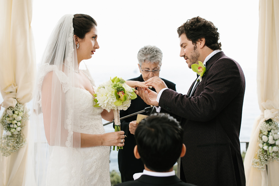 groom putting the wedding ring on