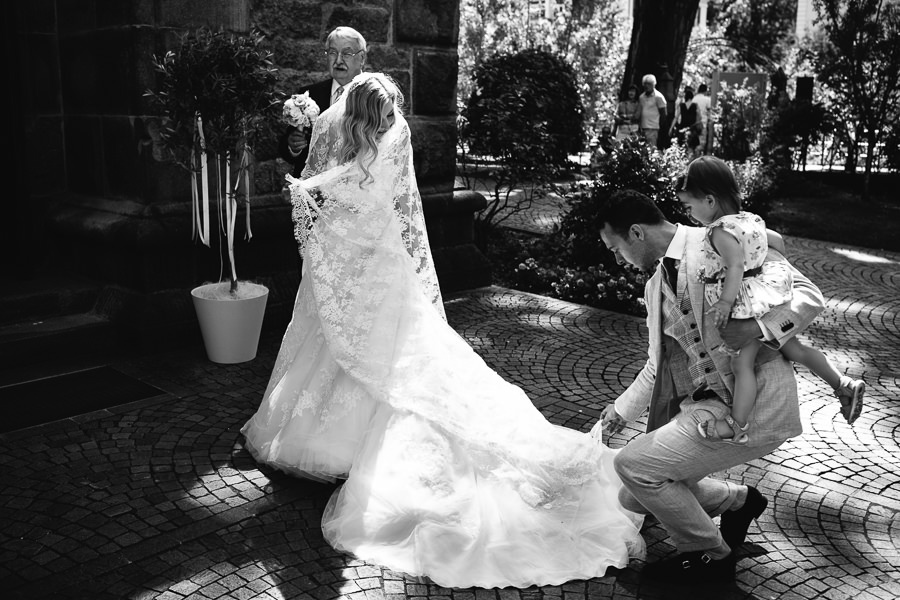 bride with her dress in front of church