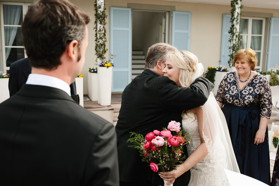 father hugging his daughter on wedding on lake como