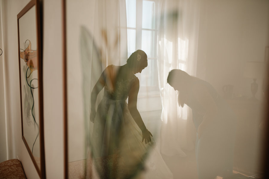 bride putting on her dress for wedding at tenuta mocajo