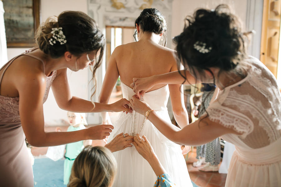 Bride putting on her dress at Castello di Meleto