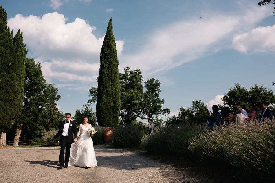 bride and groom walking down the aisle to castello di meleto